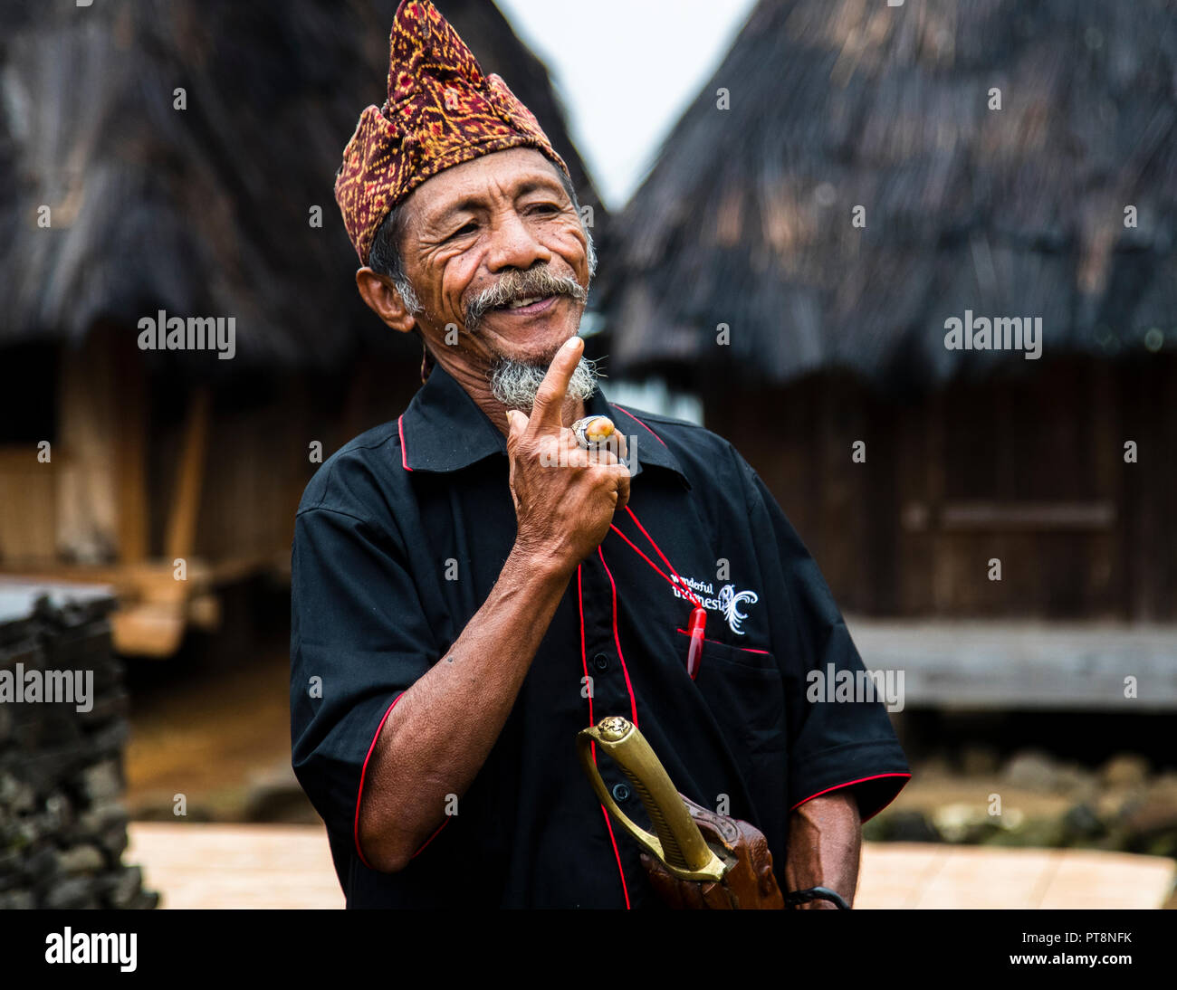 The village chief raises his index finger and smiles during his address in a mountain village near Moni, Flores, Indonesia. Stock Photo