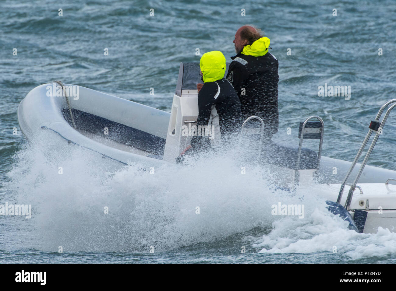 man and woman in rib rigid inflatable boat in rough seas or weather Stock Photo