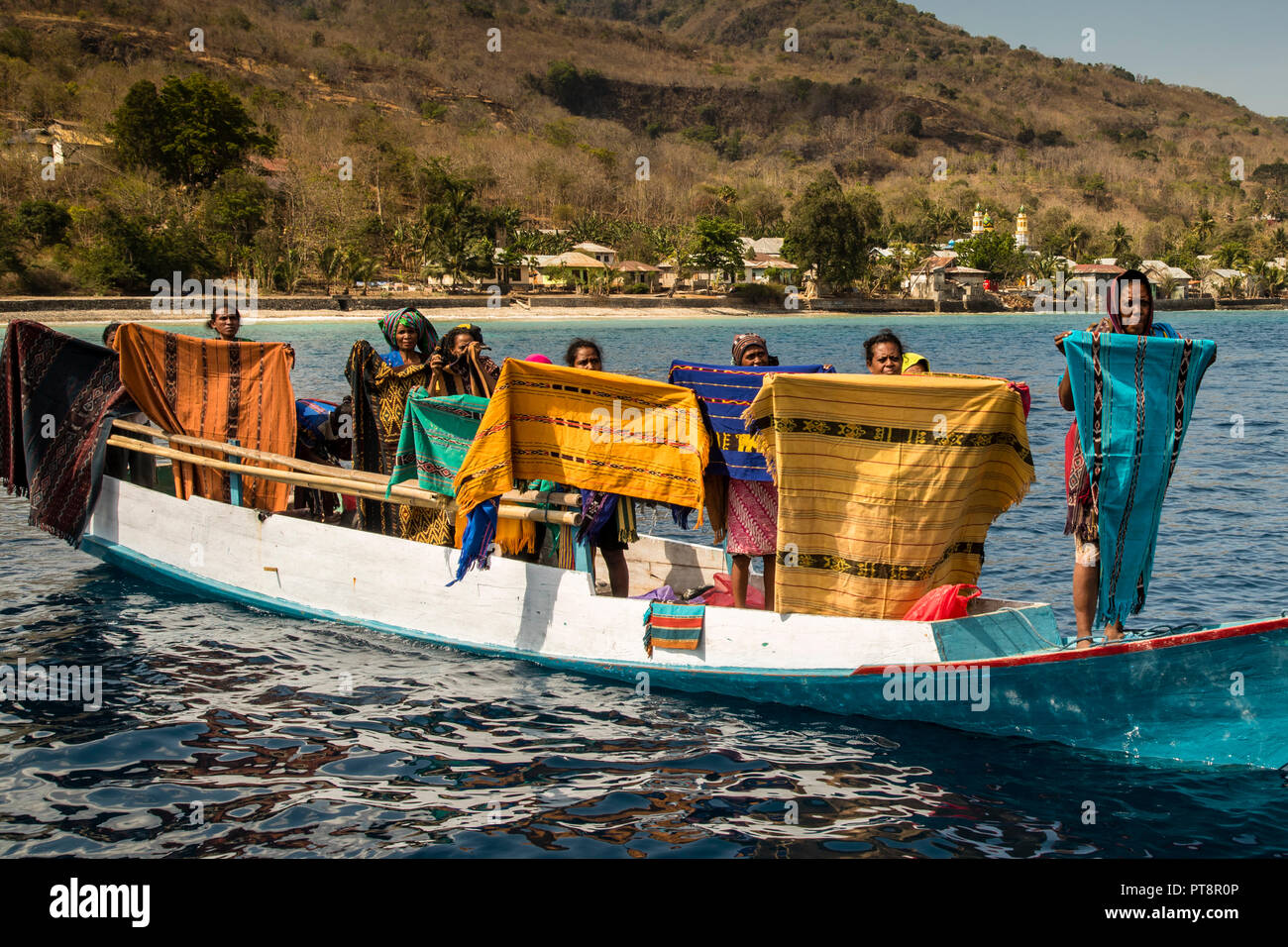 Indonesian sellers offer their textiles from boat, Sunda Islands, Indonesia Stock Photo