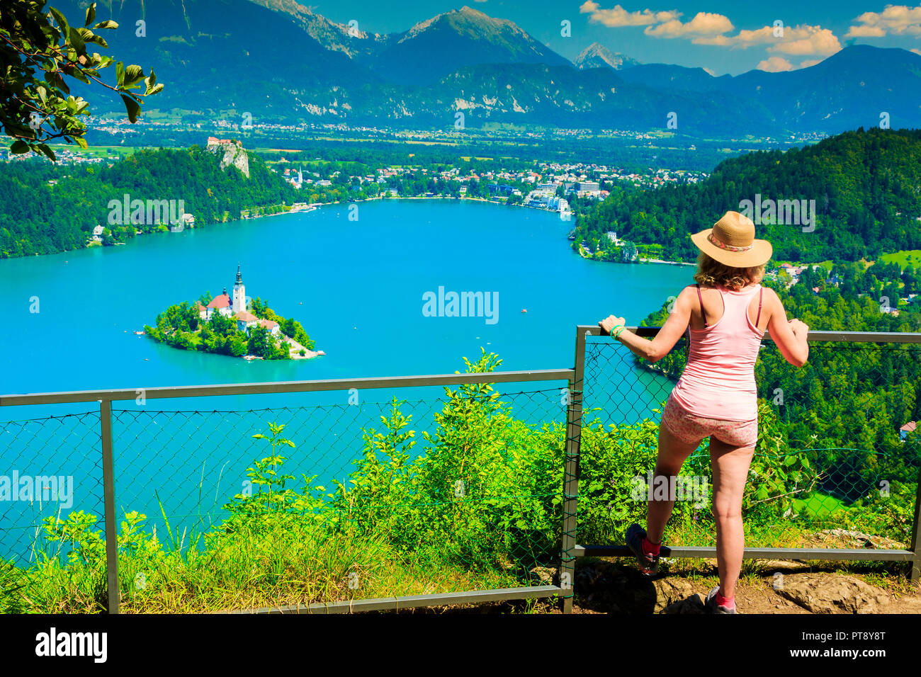 Woman looking a lake landscape from a viewpoint. Stock Photo