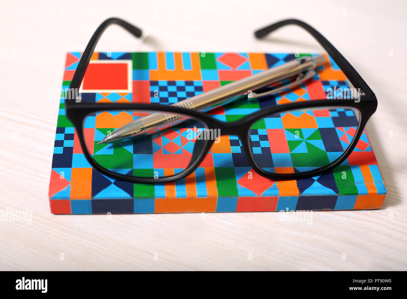 Picture of glasses and pen on the notebook. Stock Photo