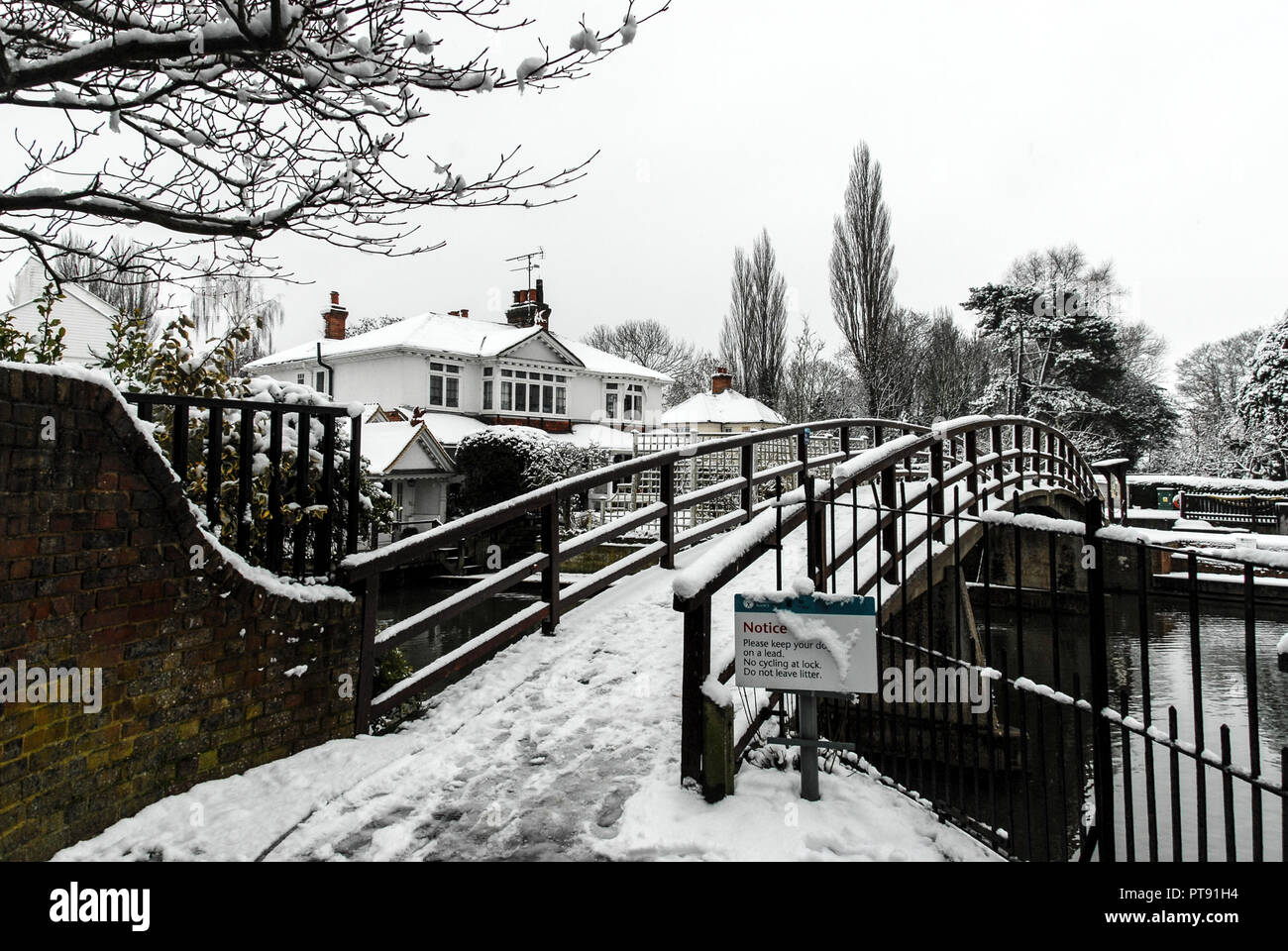 Winter snow scene at Marlow Lock and footbridge over the river Thames at Marlow in Buckinghamshire, Britain Stock Photo