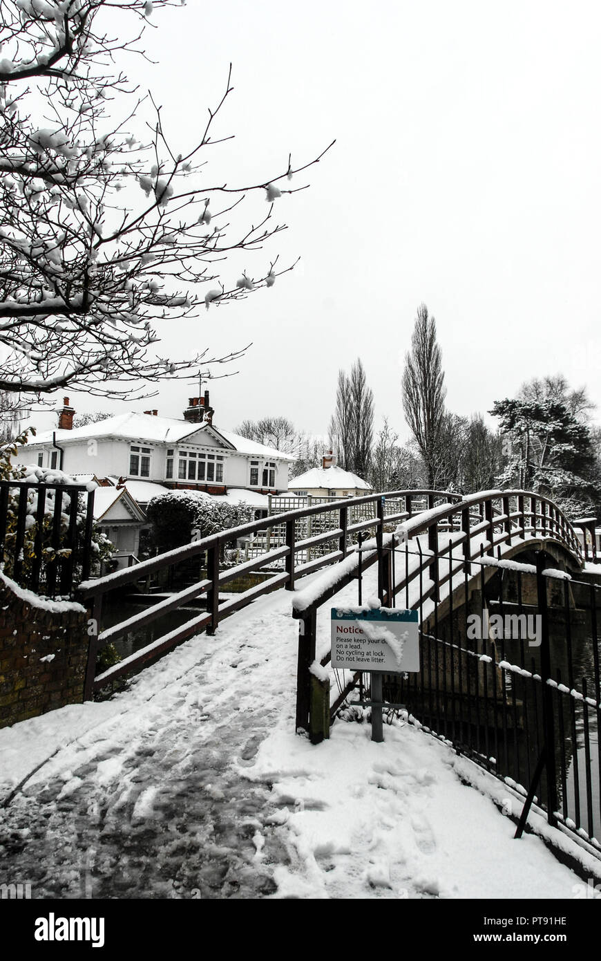 Winter snow scene at Marlow Lock and footbridge over the river Thames at Marlow in Buckinghamshire, Britain Stock Photo
