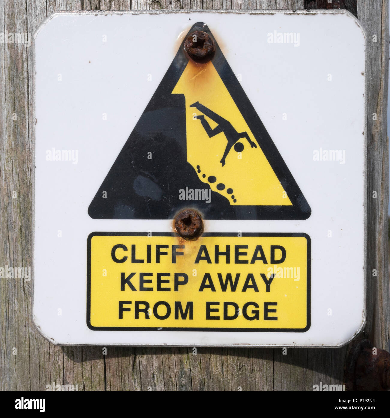 Cliff danger warning sign. Keep away from the cliff edge concept, falling off, falling man pictogram. Stock Photo