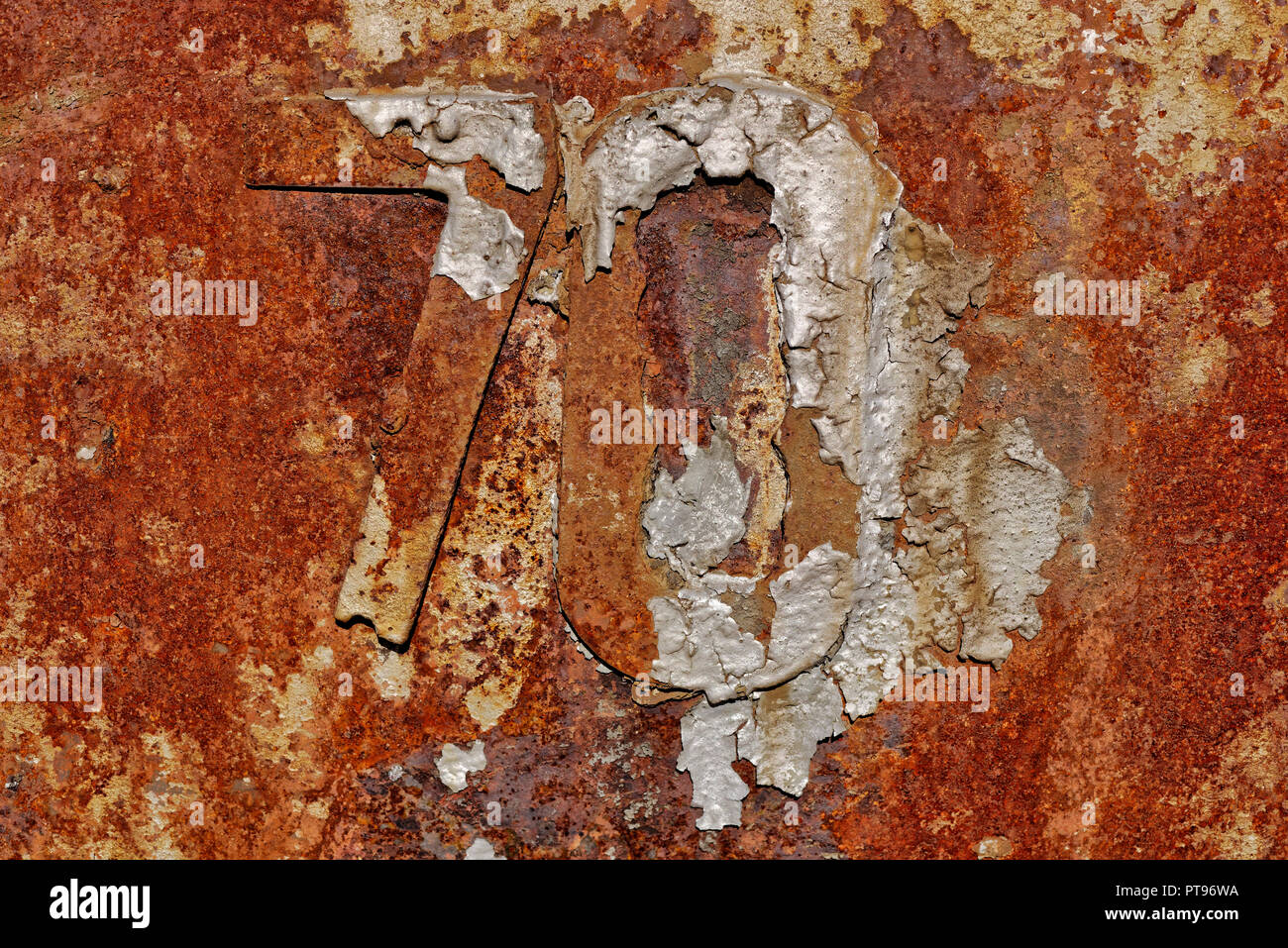 Backgrounds and textures: very old rusty metal wall surface, with number 70, industrial abstract Stock Photo