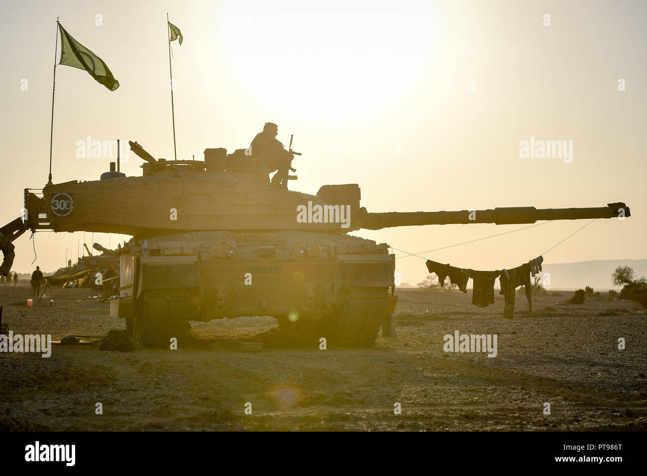 The sun sets over a Challenger II Main Battle Tank in the Oman desert, where UK forces are taking part in a month-long Exercise, Saif Sareea 3. Stock Photo