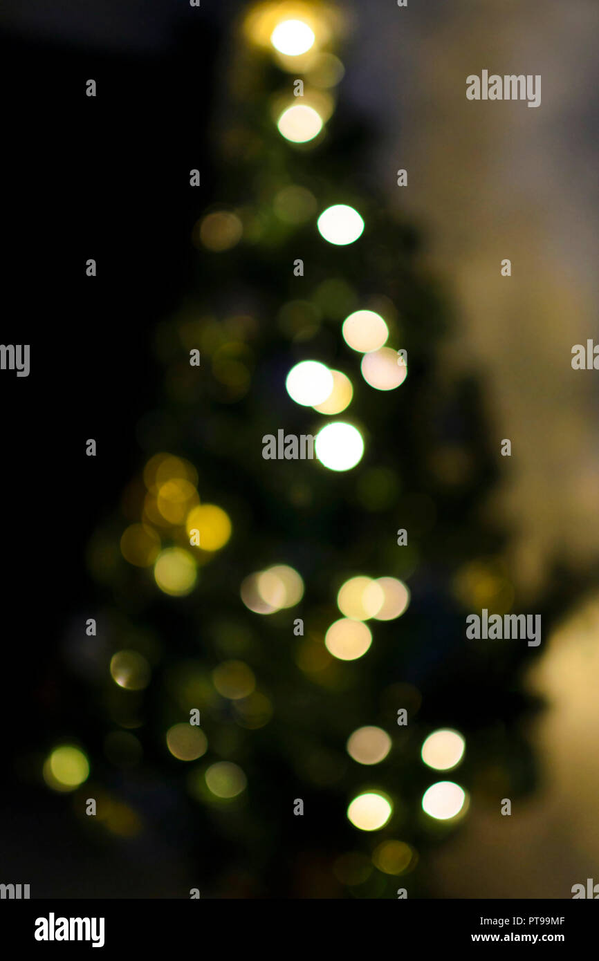 Multicolored bokeh on the Christmas tree vertical festive background. Holidays photo. Stock Photo