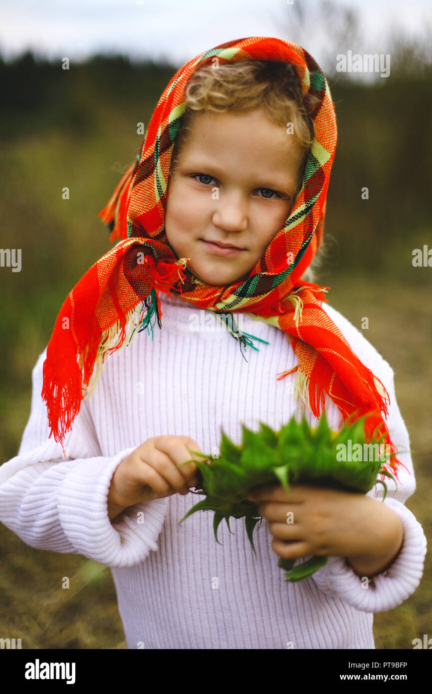 little girl in the field with sunflower little girl in a headscarf