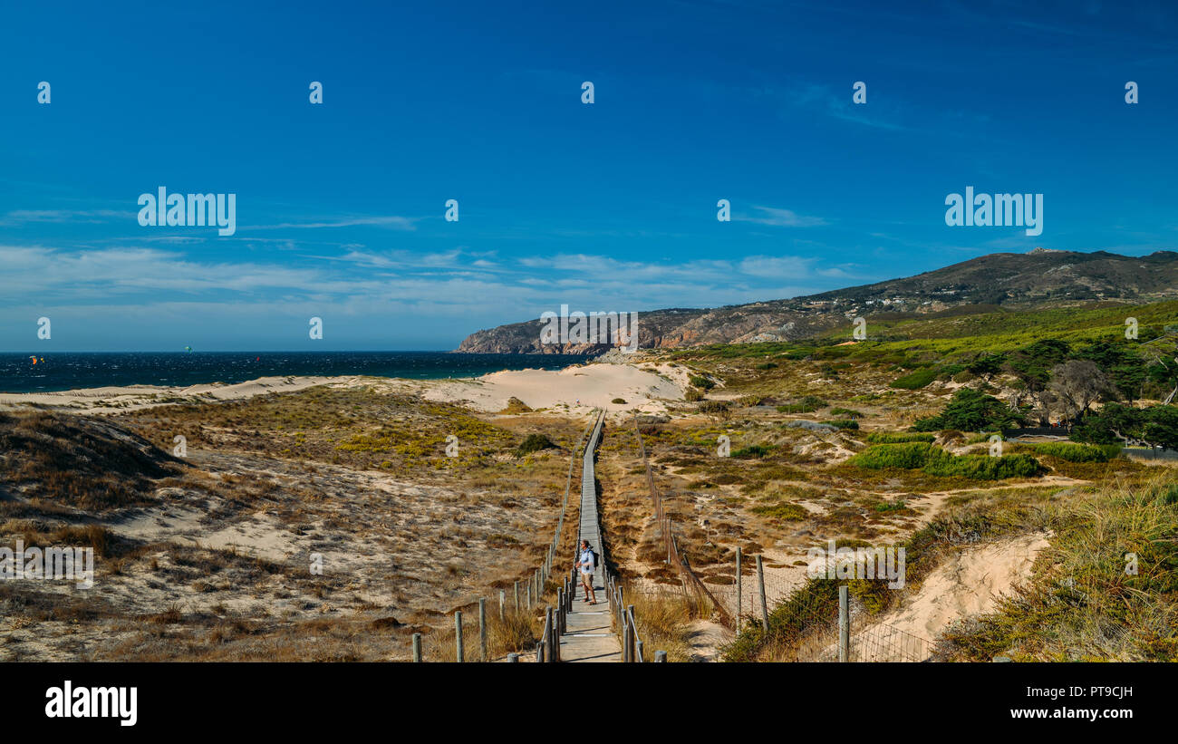 Guincho, Portugal - Oct 6, 2018: Tourists at steps that lead to the Atlantic Ocean found in Guincho beach near Lisbon, Portugal Stock Photo