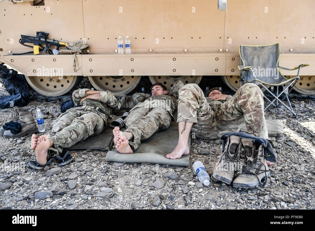 British soldiers remove their boots during a pause in manoeuvres in the searing heat of the Oman desert, where UK forces are taking part in a month-long exercise, Saif Sareea 3. Stock Photo