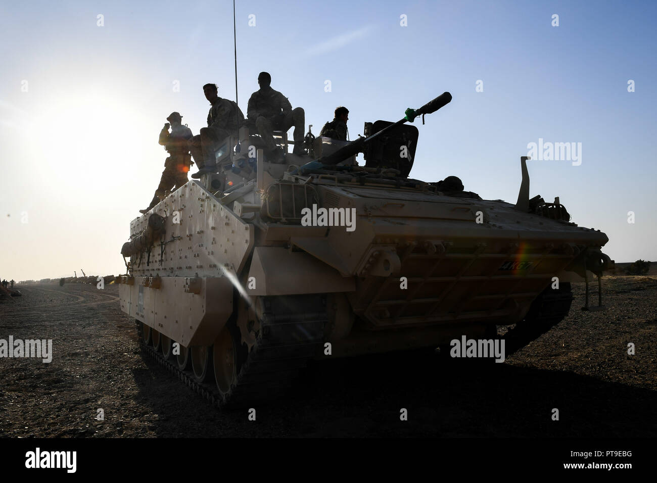 A Warrior armoured fighting vehicle crew rest on top their wagon in the Oman desert, where UK forces are taking part in a month-long exercise, Saif Sareea 3. Stock Photo