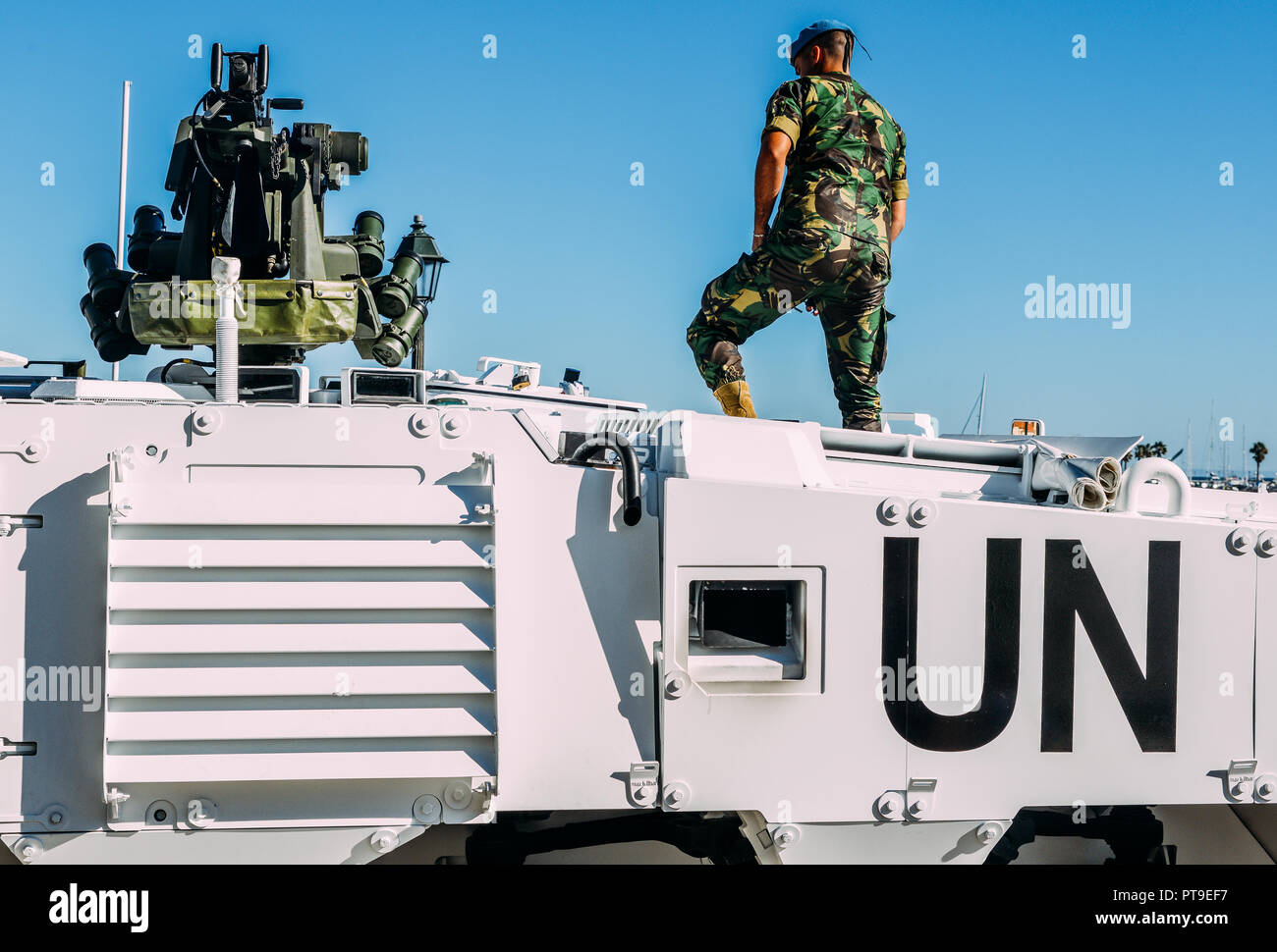 Close up of United Nations peacekeeping tank vehicle with machine gun mounted on top and unidentifiable soldier in uniform Stock Photo