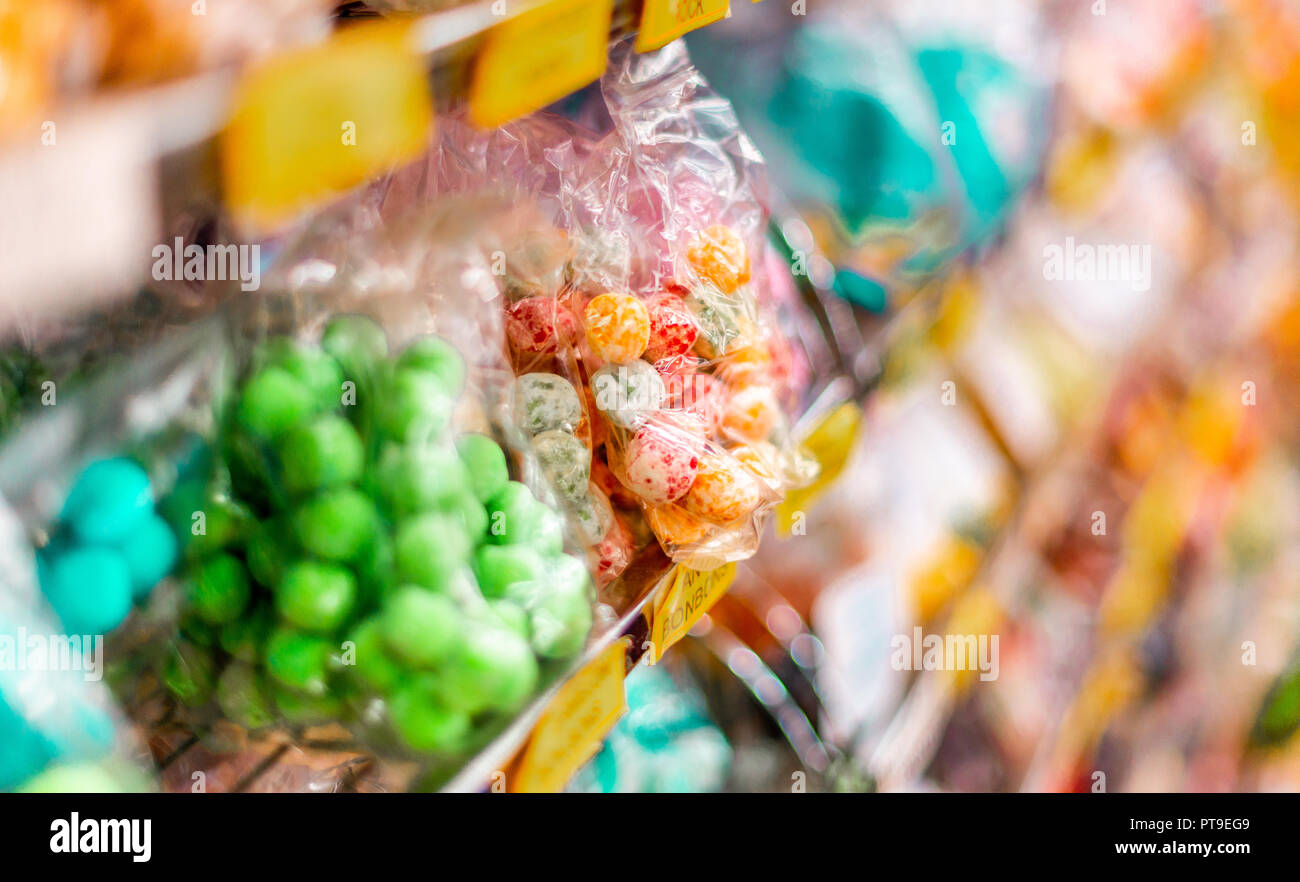 Tasty looking green,  red and yellow Sweets and Candy in a wrapper on a shelf of a sweet shop in Matlock, UK Stock Photo