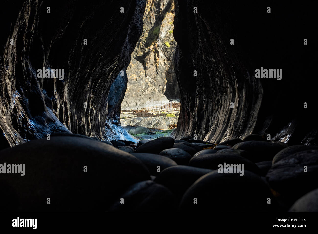 Inside a wave eroded crack in the rock at Trevine bay, Pembrokeshire, Wales. Stock Photo