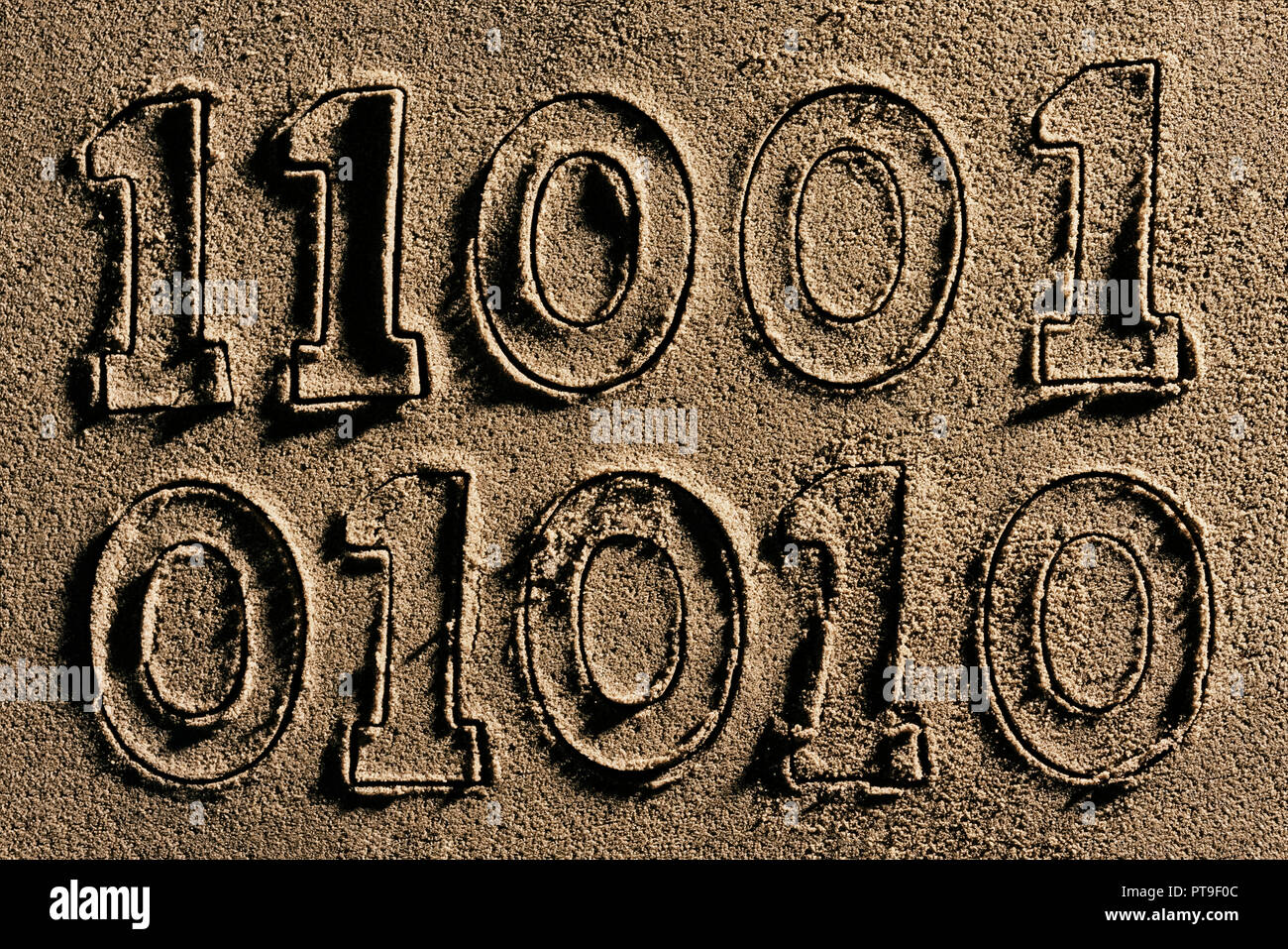 A series of binary ones and zeros numbers  cut into wet sand. Stock Photo