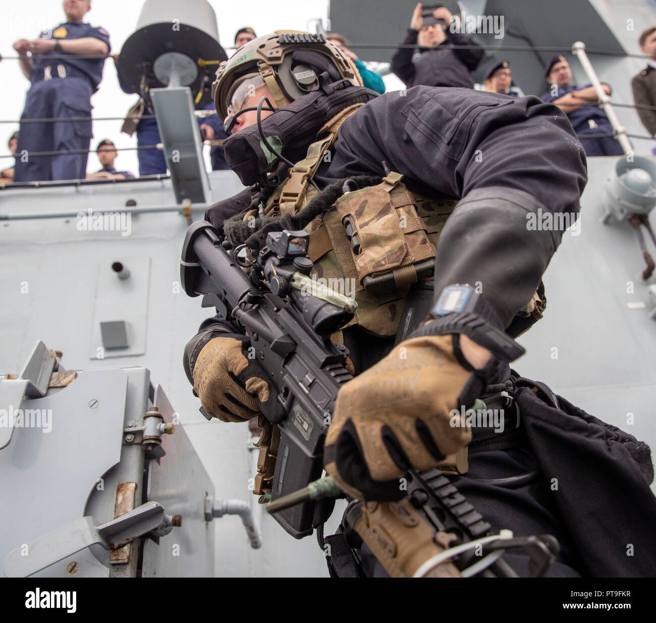 Royal Marines commandos perform a raid on a ship watched by Defence Secretary Gavin Williamson during a visit to HMS Montrose at HMNB Devonport, Plymouth. Stock Photo