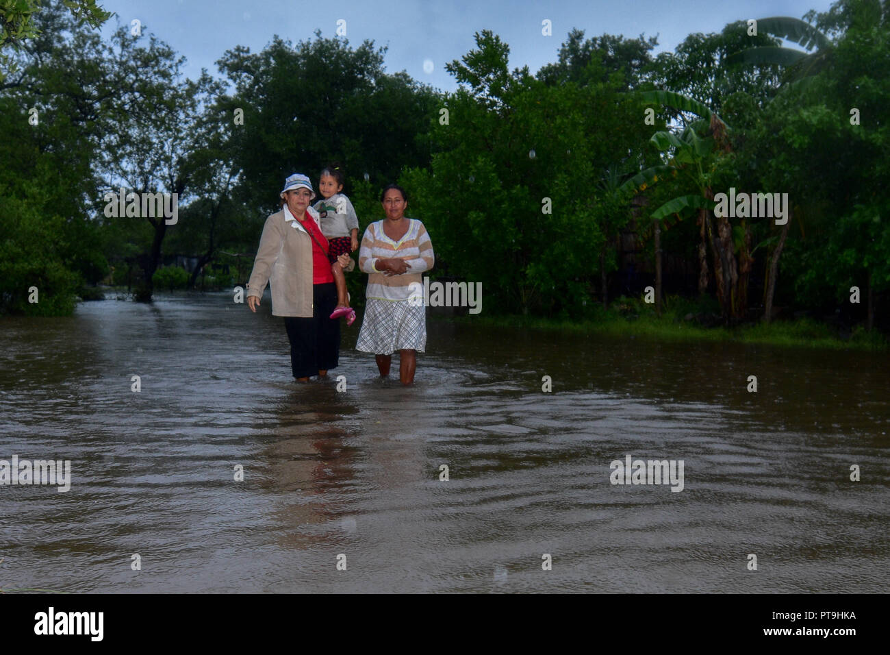Sonsonate, El Salvador, 07th October, 2018, Women carry out a girl from their homes after their hometown Barra Salada flooded. Credit: Camilo Freedman Credit: Camilo Freedman/Alamy Live News Stock Photo