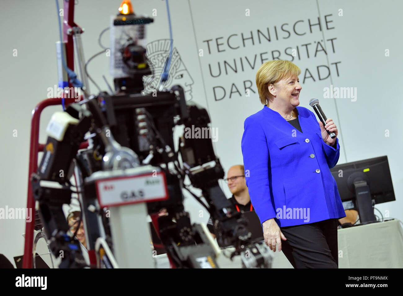 Darmstadt, Hessen, Germany. 08th Oct, 2018. Chancellor Angela Merkel (CDU) stands next to humanoid robot Johnny during a visit to the Technical University. During a demonstration, search and rescue robots from the 'Hector' team are used, which can, for example, search autonomously for buried people. Credit: Uwe Anspach/dpa/Alamy Live News Stock Photo