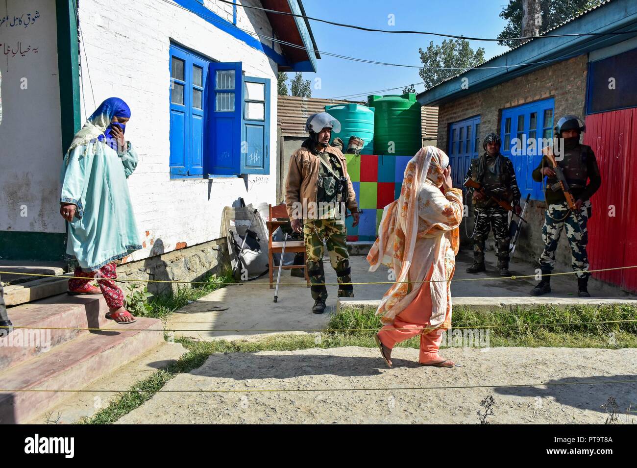 Kashmiri voters walk out of a voting booth at a polling station during the first phase of local elections in Srinagar, Indian administered Kashmir. Amid tight security arrangements, voting began for the first phase of the urban local bodies (ULB) elections in Jammu and Kashmir on 08 October. Stock Photo
