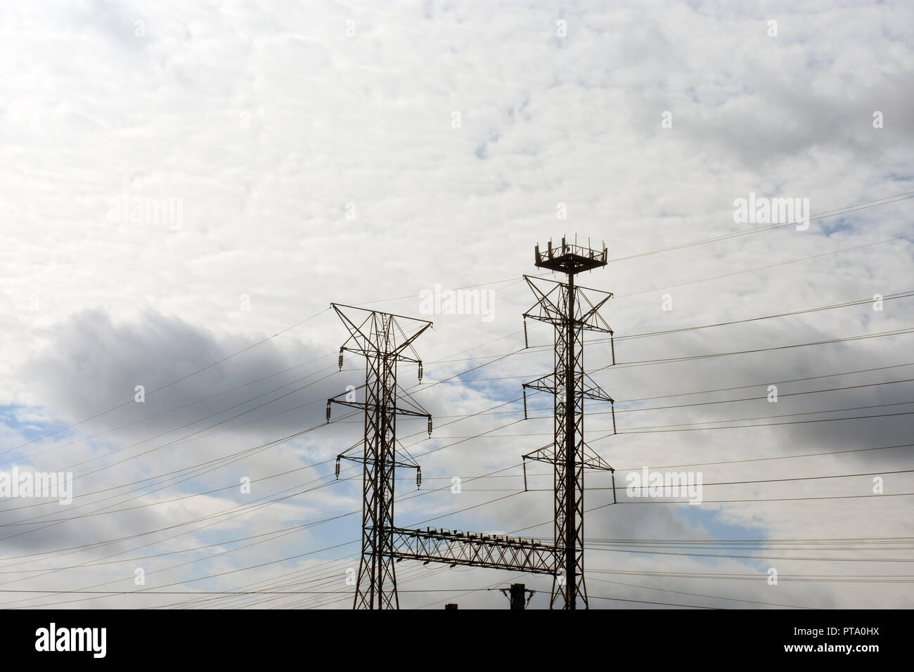 High voltage electrical power tower and cables on a partly cloudy day Stock Photo