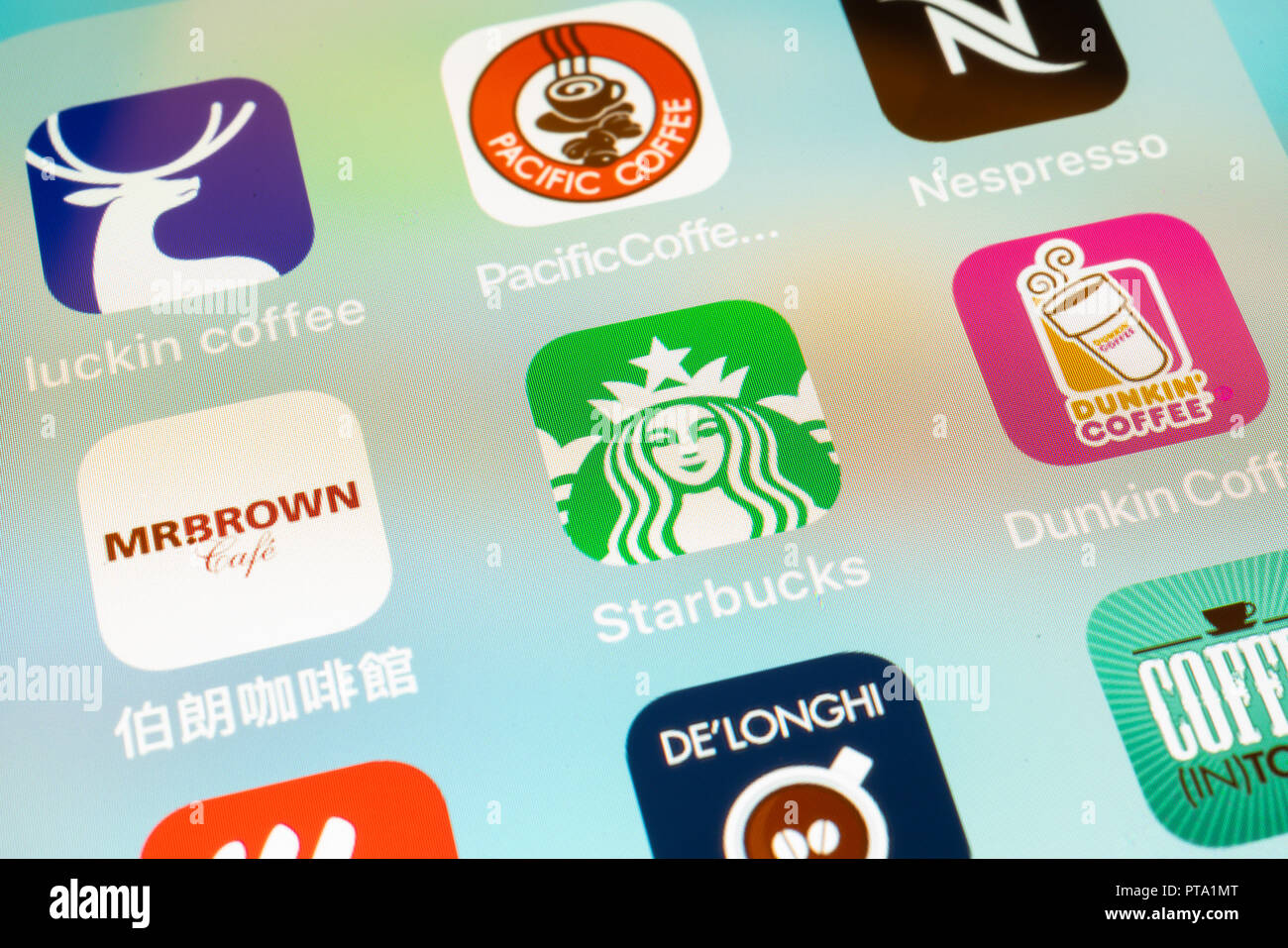 6 October 2018, Wuhan China : Several coffee apps icons on an iphone screen closeup with Starbucks coffee logo in center Stock Photo