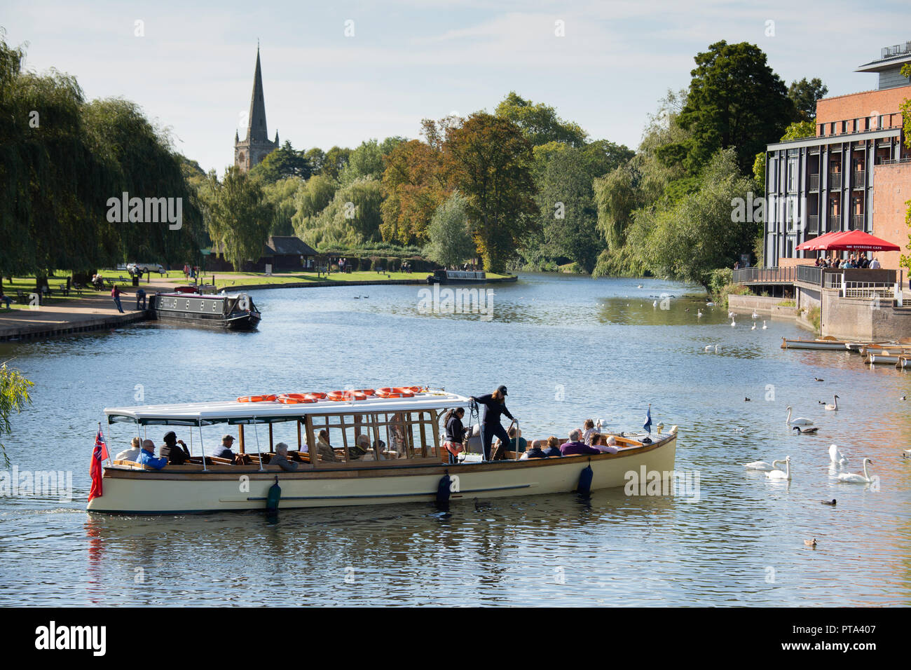A river cruise ship taking tourists and visitors along the River Avon in Stratford upon Avon on a bright Autumnal day. Stock Photo
