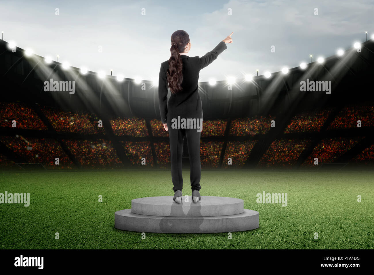 Rear view of asian business woman standing on podium at stadium Stock Photo