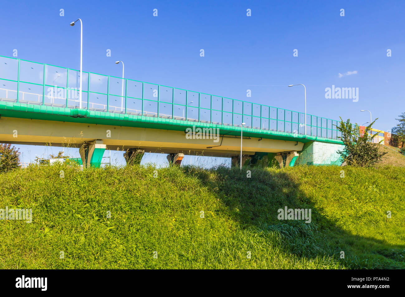 Sound absorbing screens on the highway and overpass and green grass on
