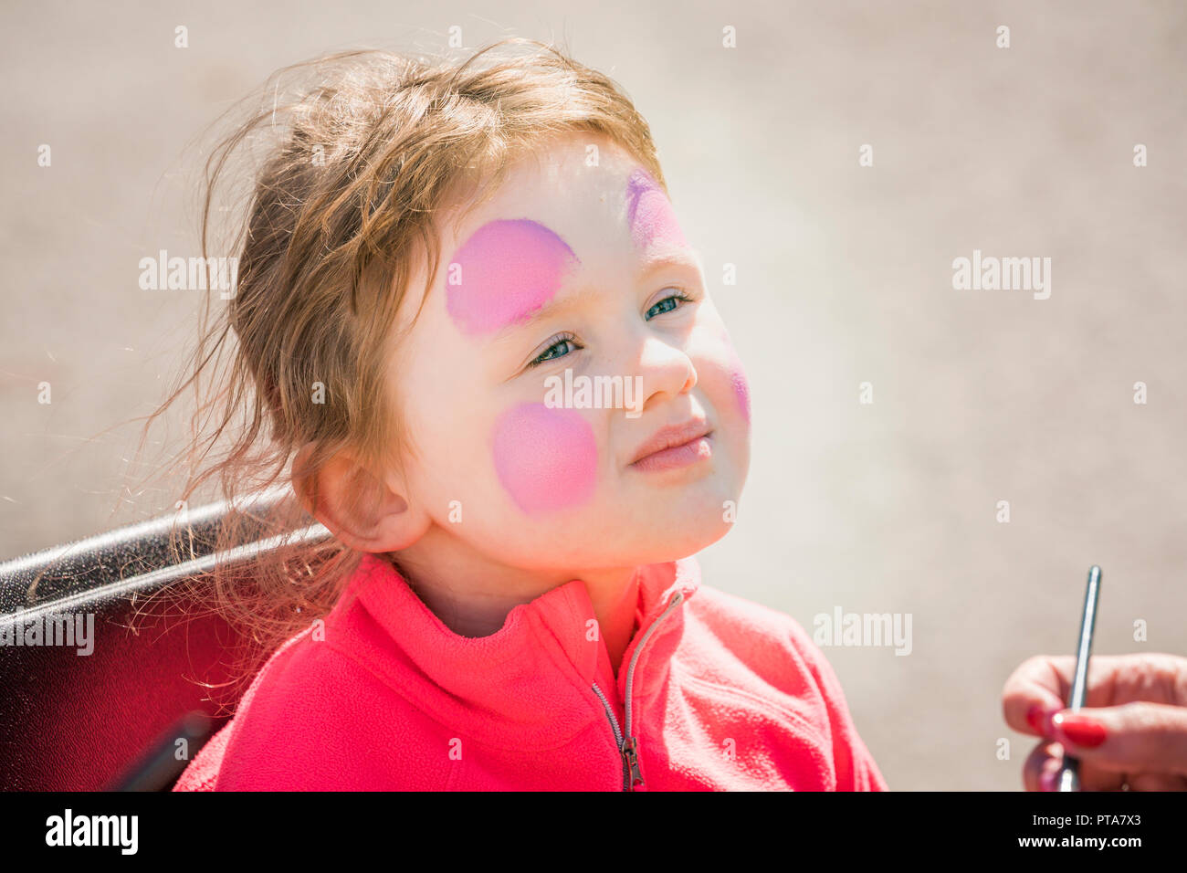 Young Girl having her faced painted during a summer festival, Seaman's Day, (Sjomannadagurinn) Reykjavik, Iceland Stock Photo