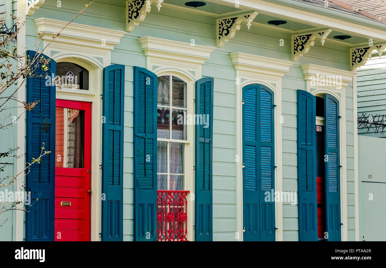 A red door complements a double shotgun house in the French Quarter, Nov. 15, 2015, in New Orleans, Louisiana.  Shotgun houses are named for their rec Stock Photo