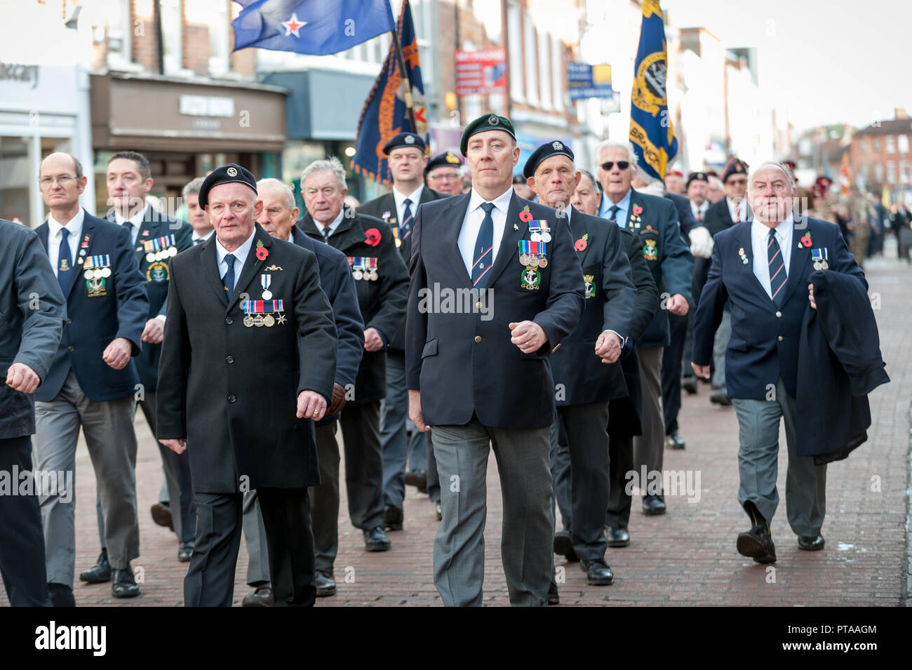 Remembrance Sunday parade, veterans carrying standards march through the city of Chichester, West Sussex, UK. Stock Photo