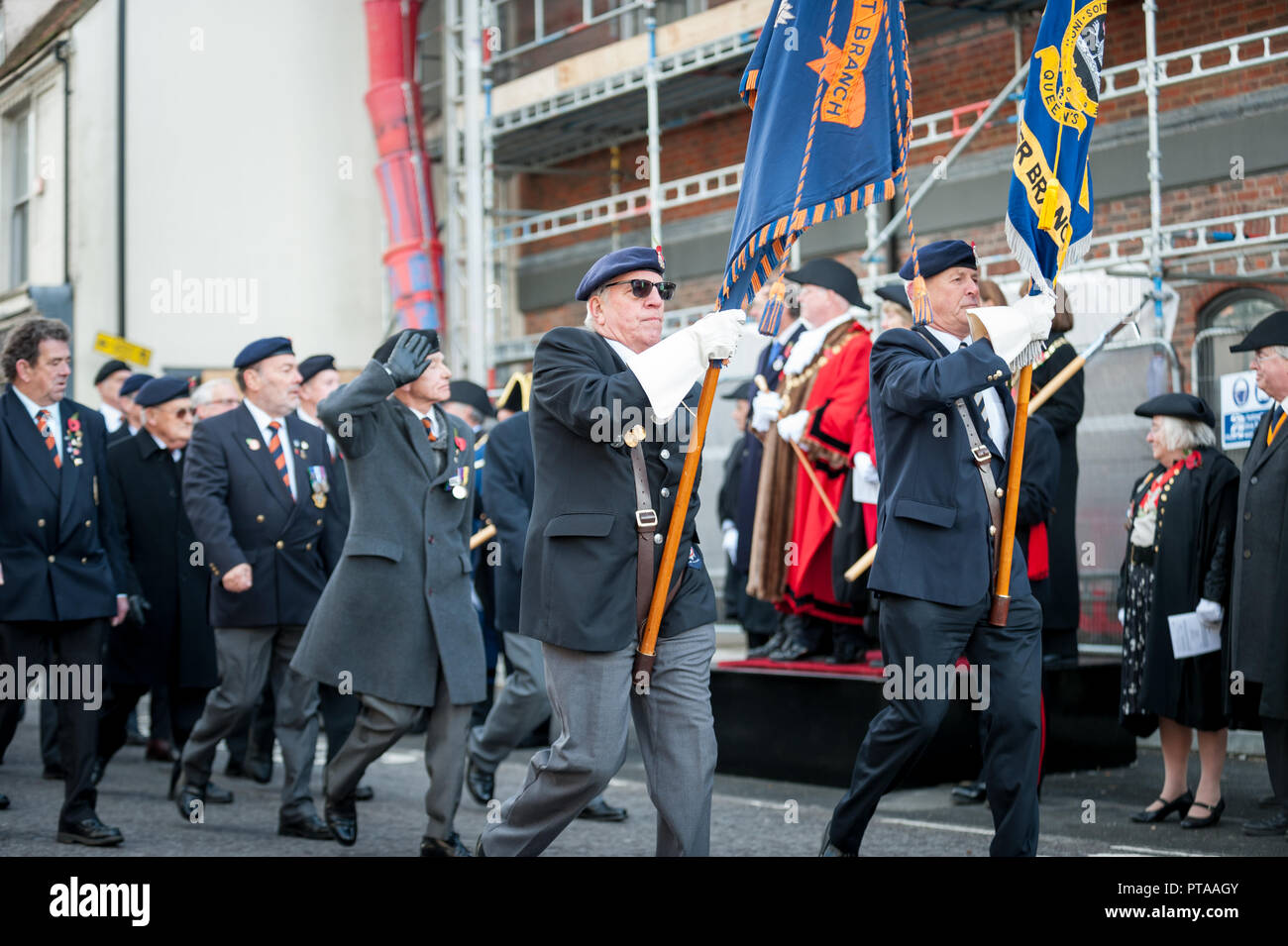 Remembrance Sunday parade, veterans carrying standards march through the city of Chichester, West Sussex, UK. Stock Photo