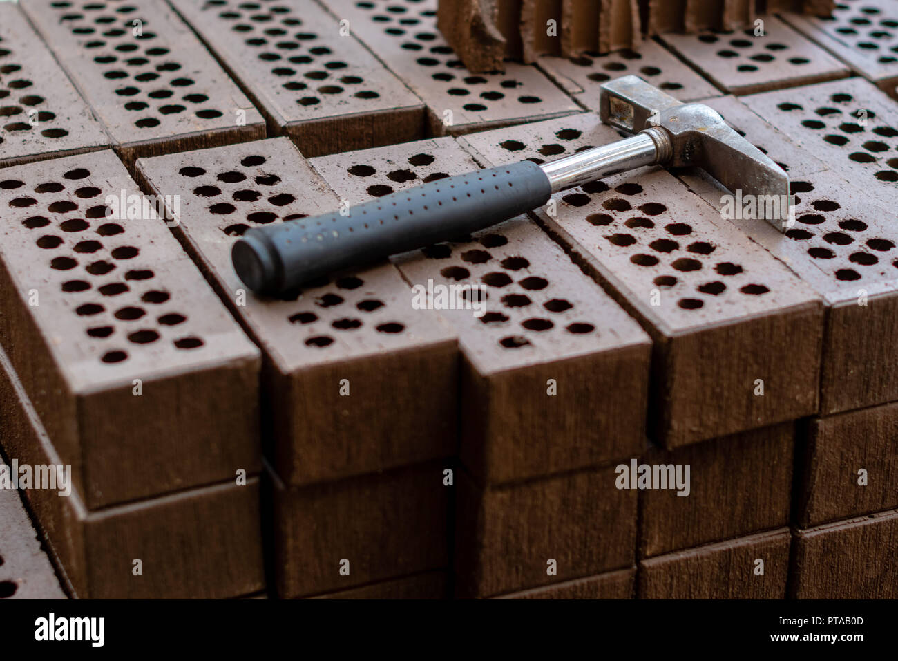 A hammer is laid on a red brick stack. Stock Photo