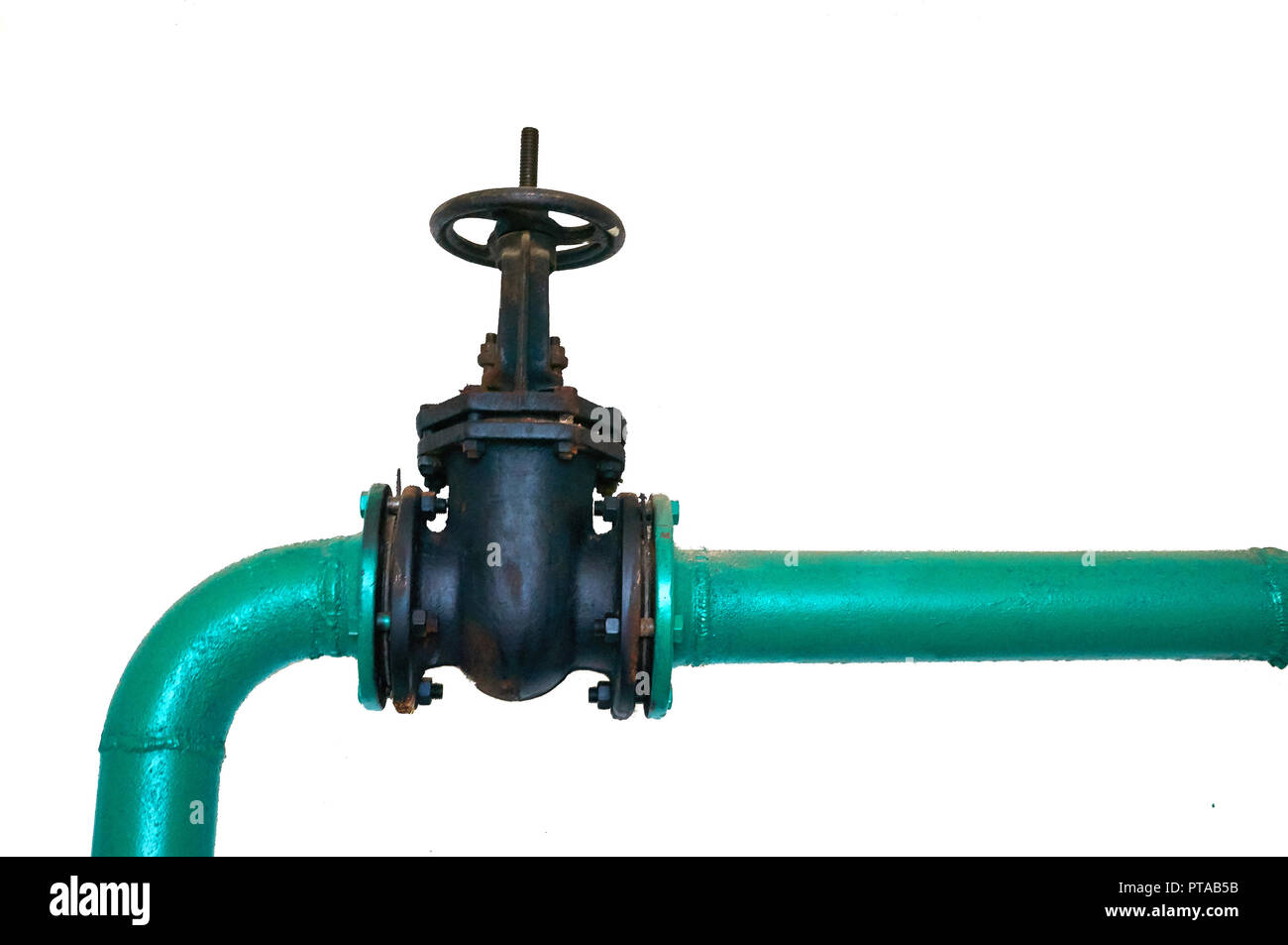 Old black valve on a cold water pipeline painted green isolated on a white background. Industrial background. Stock Photo