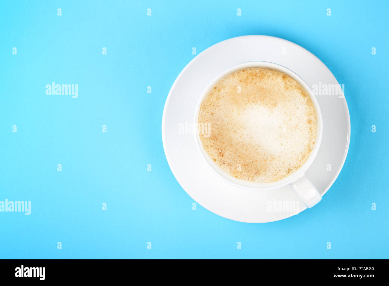 Close up one full white cup of frothy latte cappuccino coffee and ...