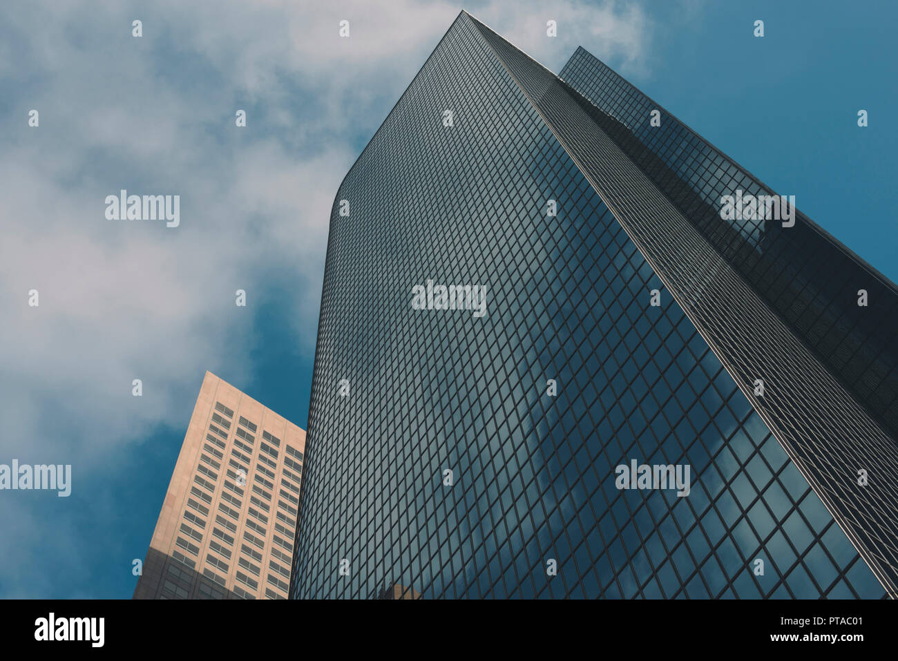 View of two tall city office buildings and blue sky Stock Photo - Alamy