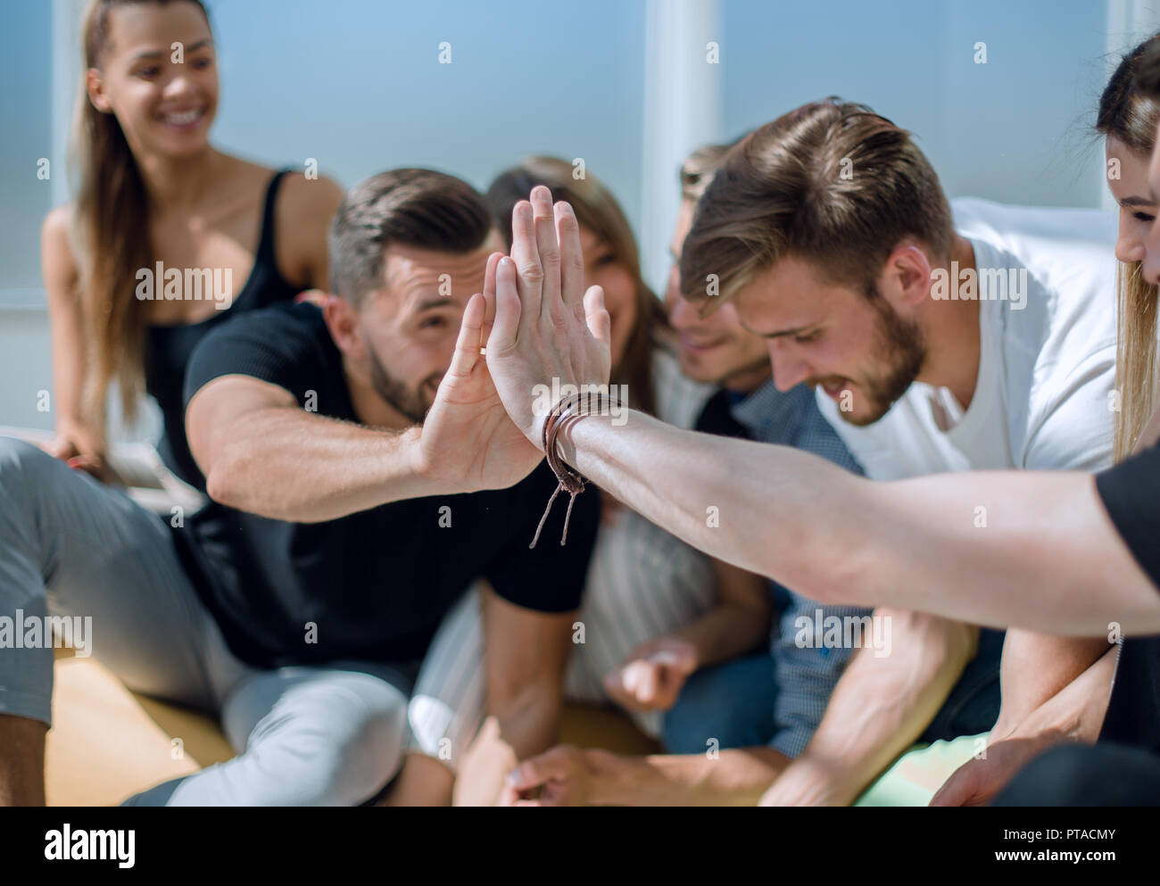 young employees giving each other a high five Stock Photo - Alamy