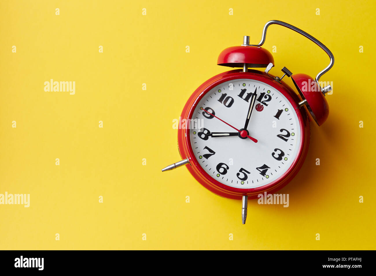 Red vintage alarm clock on yellow background. Alarm clock with place
