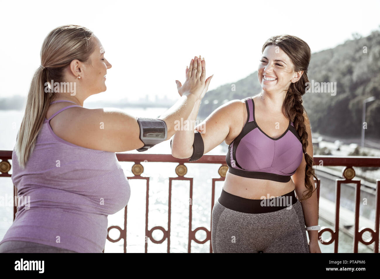 Delighted nice women giving high five to each other Stock Photo