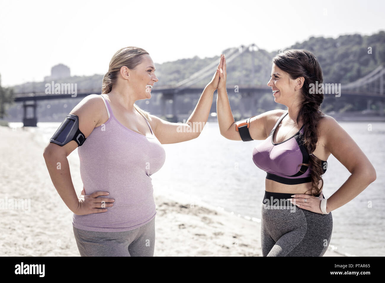 Cheerful positive women giving high five to each other Stock Photo - Alamy