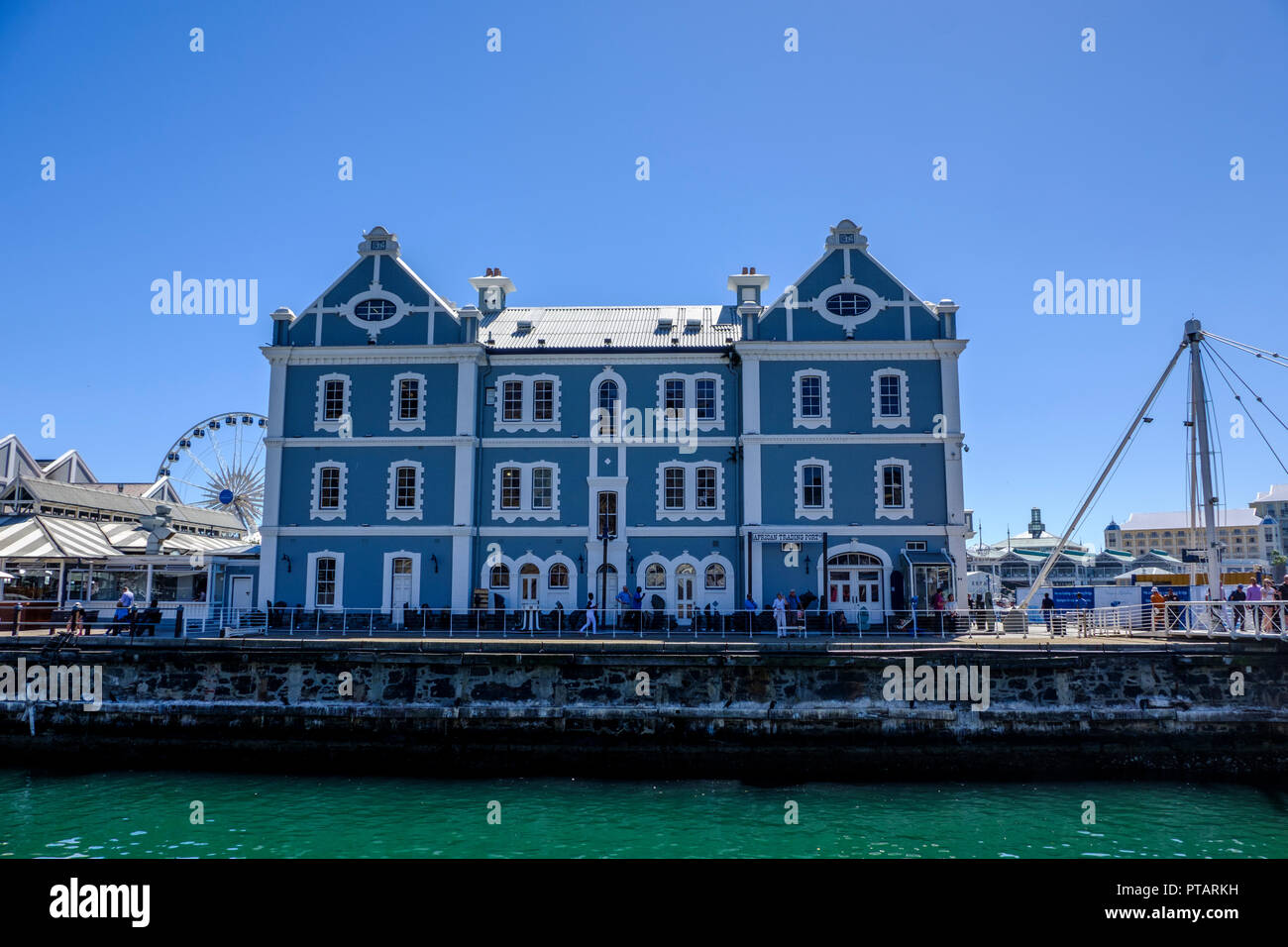 CAPE TOWN, SOUTH AFRICA – 20 MARCH 2018: Beautiful blue and white African Trading Port building at Cape Town's V & A Waterfront against clear blue sky Stock Photo