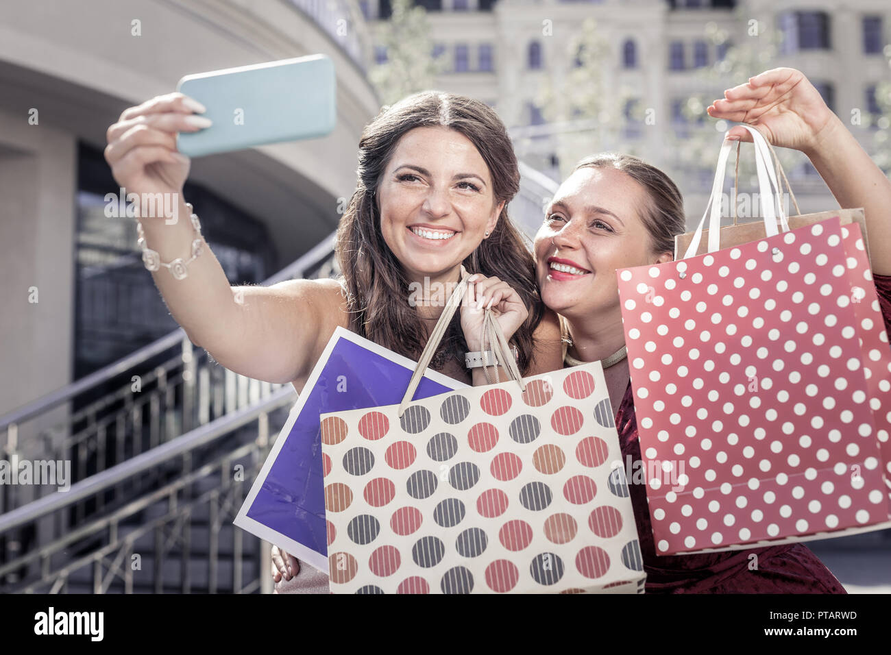 Happy delighted women showing their shopping bags Stock Photo