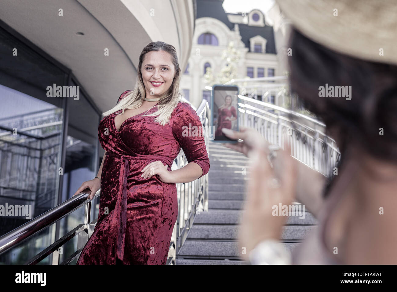 Joyful plump woman wearing a red velvet dress Stock Photo
