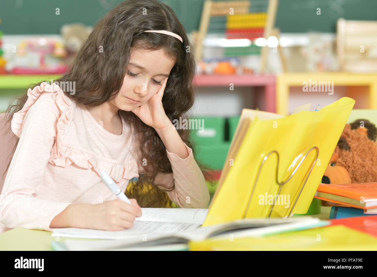 Portrait of a schoolgirl doing homework in classroom Stock Photo - Alamy