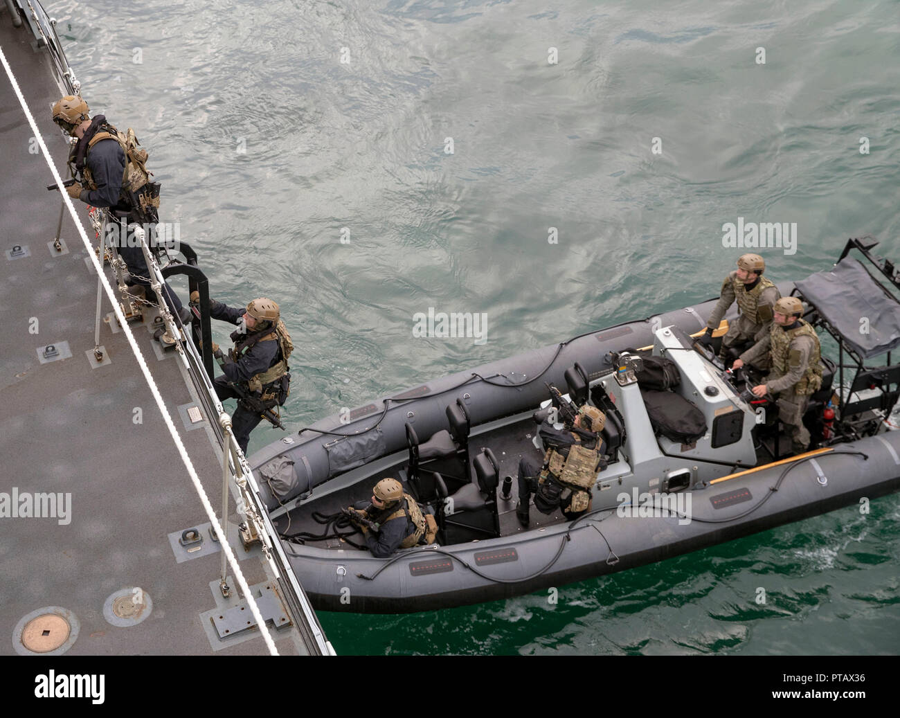 Royal Marines commandos perform a raid on a ship watched by Defence Secretary Gavin Williamson during a visit to HMS Montrose at HMNB Devonport, Plymouth. Stock Photo