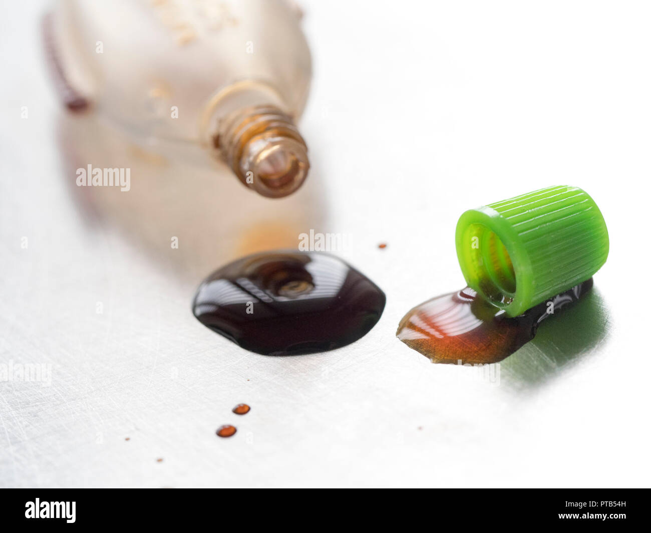 Fish shaped mini Soy sauce bottle spilling drops of sauce Stock Photo