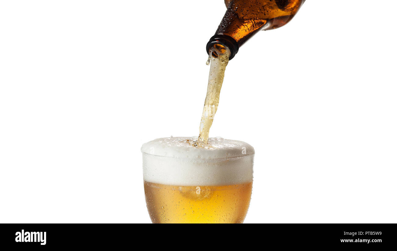 A bottle pours cold lager beer in a glass, isolated on white background