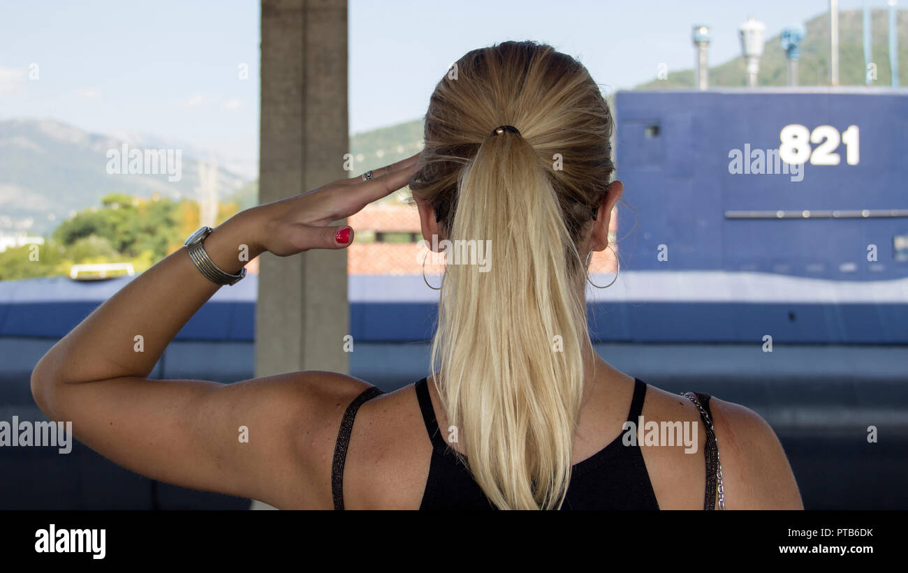 Tivat, Montenegro - View from behind of a beautiful blonde woman greeting the retired submarine of the Yugoslav Navy Stock Photo