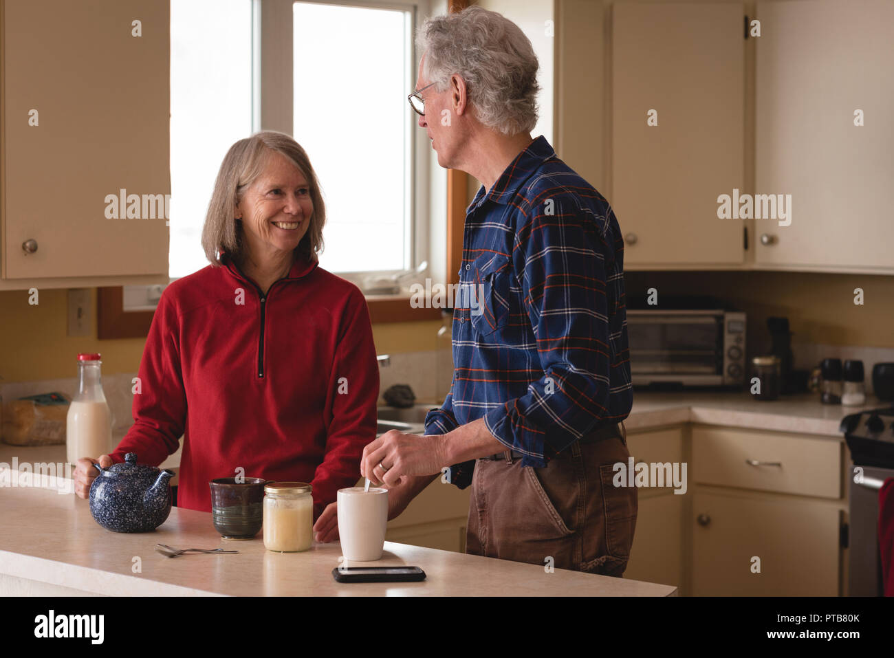 Senior couple interacting with each other while having coffee Stock Photo
