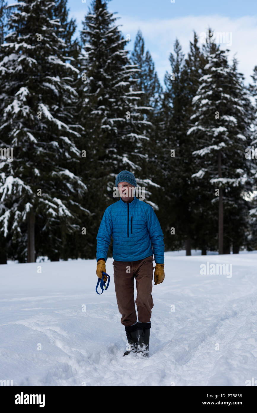 Man with dog collar standing in snowy landscape Stock Photo